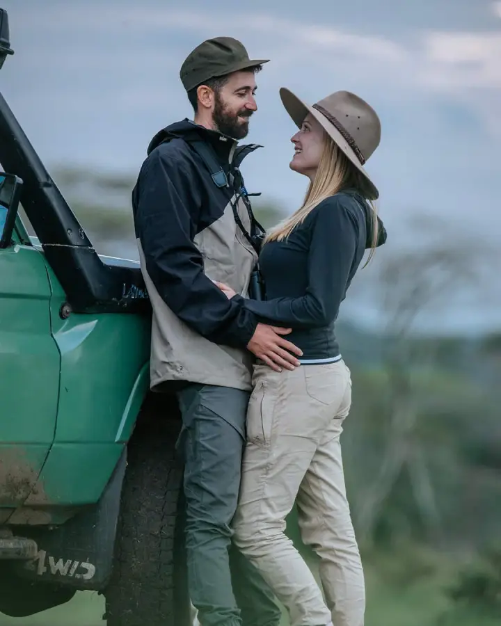 Couple beside a safari vehicle on honeymoon
